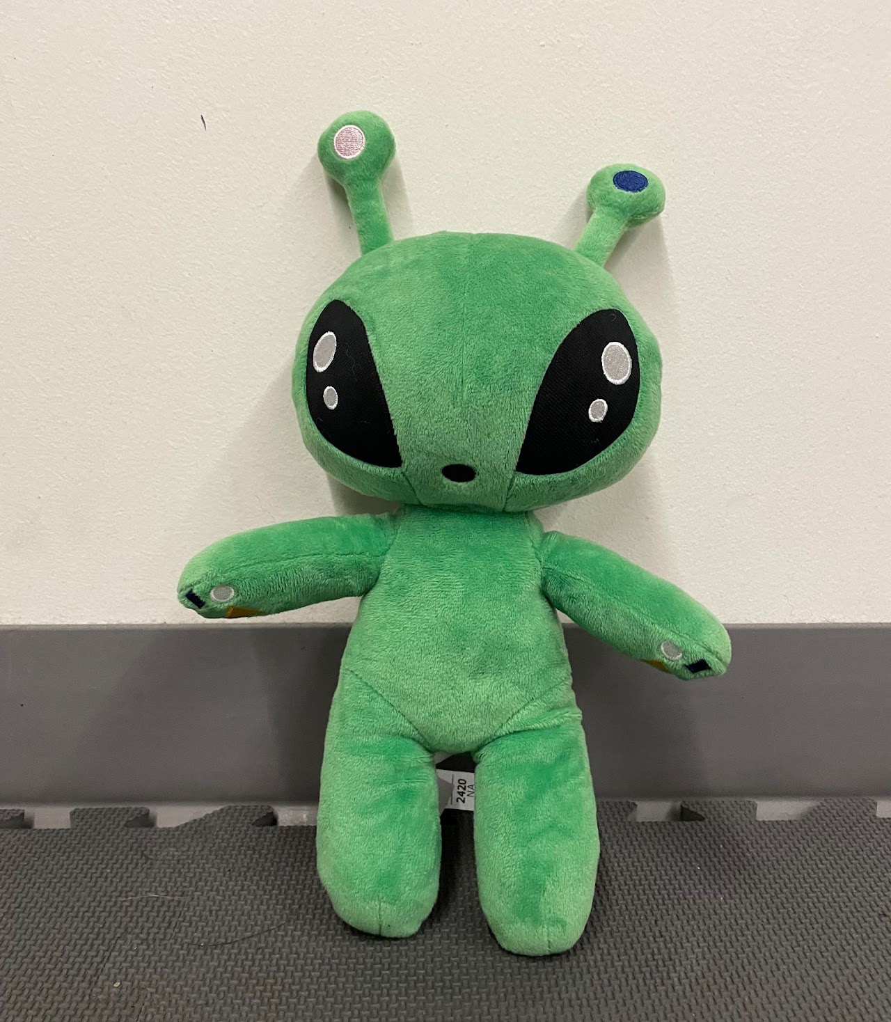 GLORP, the team's green alien plush mascot with big black eyes and antennae