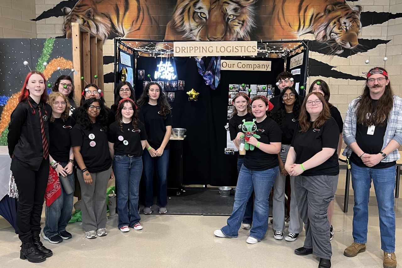 The team in front of the Dripping Logistics booth